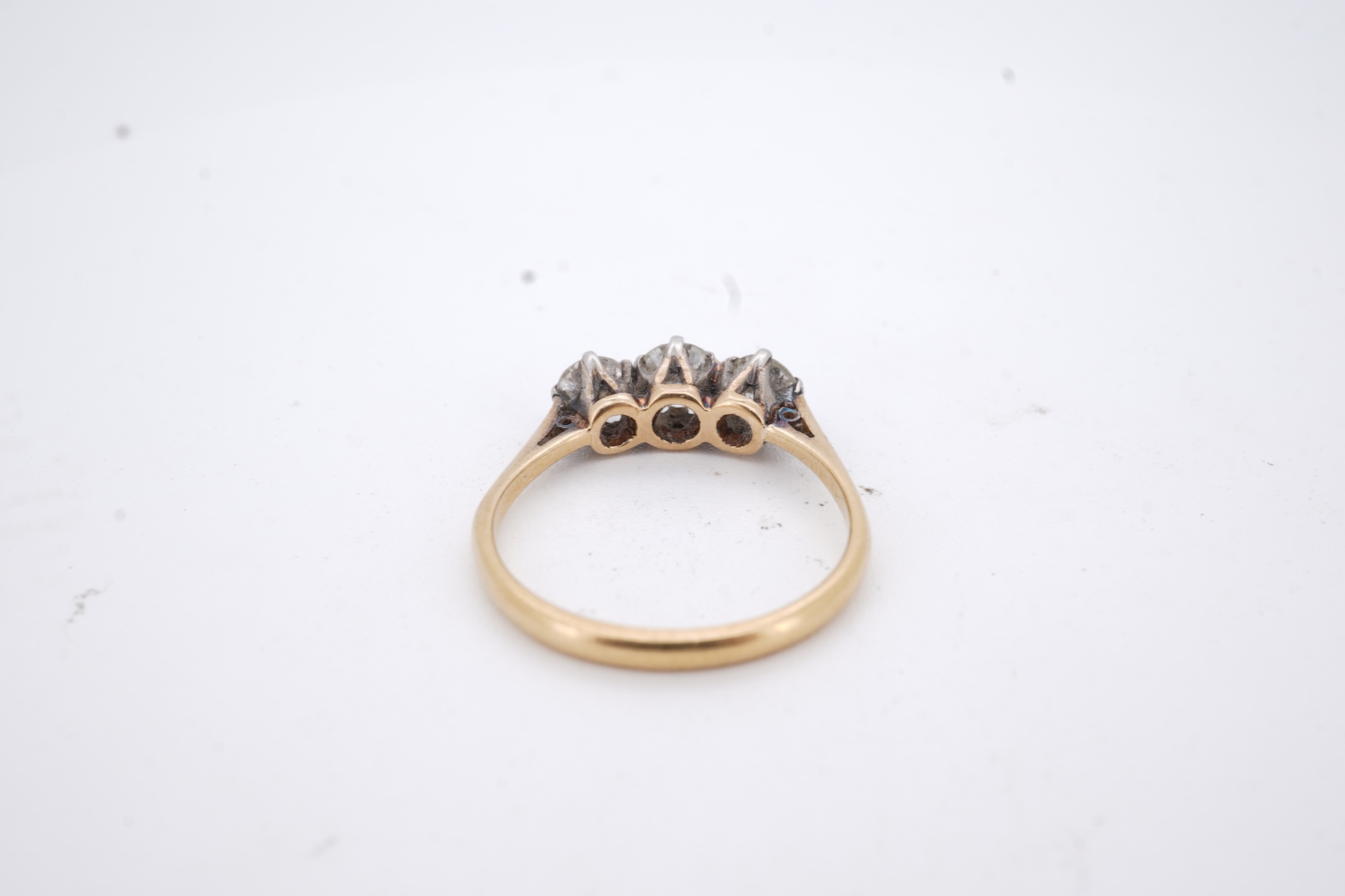 A yellow metal (stamped 18ct, & plat) and three stone diamond set ring, size L, gross weight 2.1 grams.